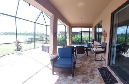 Port Malabar House | Lake view home with a screened outdoor entertainment area.