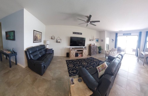 Port Malabar House | Lake view home with a screened outdoor entertainment area.