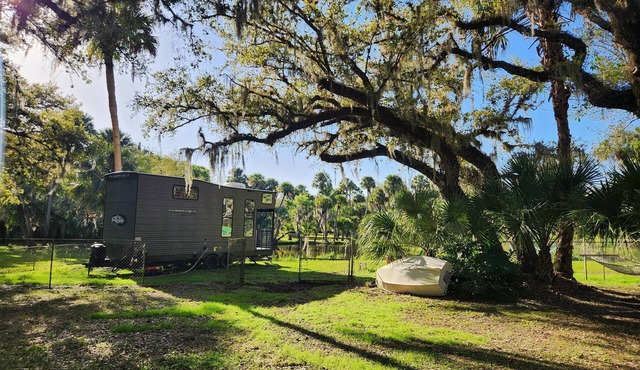 Tiny home next to private pond on 1.75 acre fenced in homestead property.